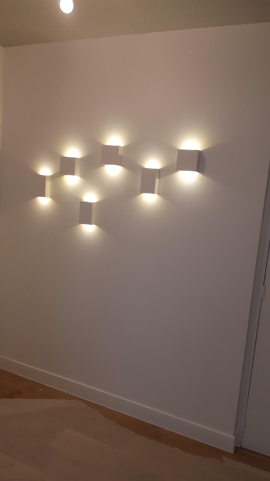 Appliques géométriques à lumière bidirectionnelle dans un appartement